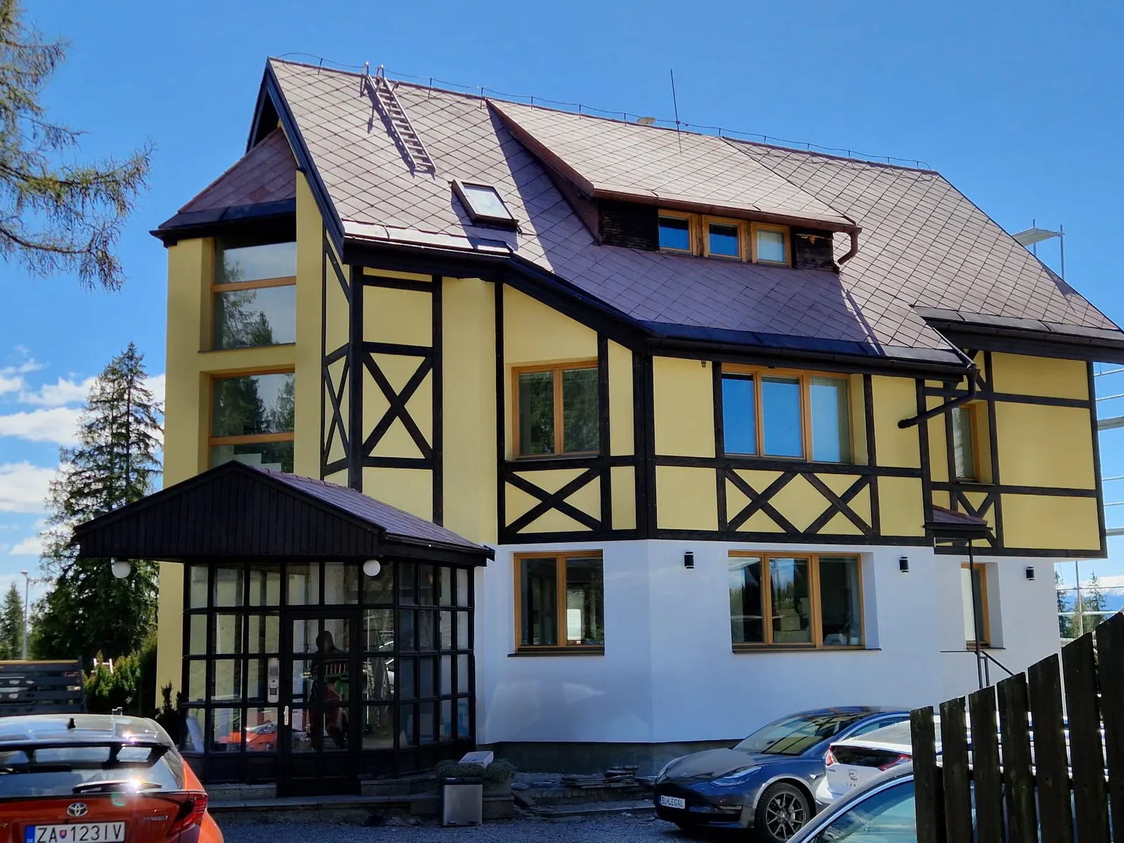 Hikers Paradise — renewed front façade after the renovation (2025): new render, restored dark timber framing, new wooden windows and a glazed entrance porch.